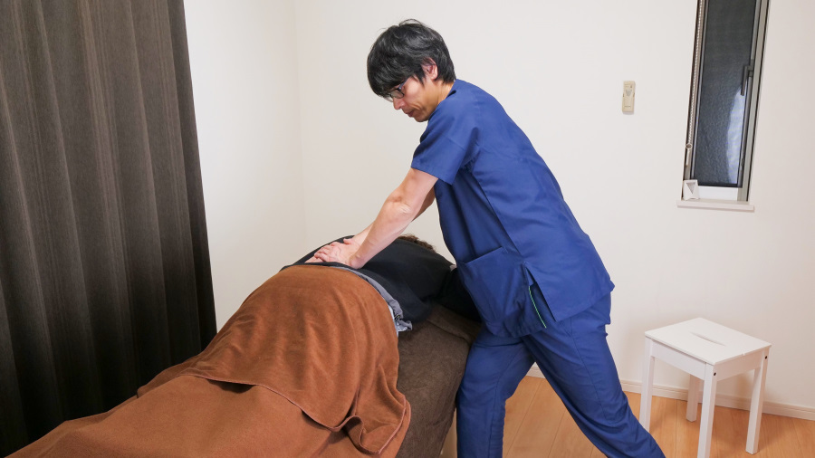 豊中市の整体院で、腰痛改善のためにベッドで腰を施術する様子